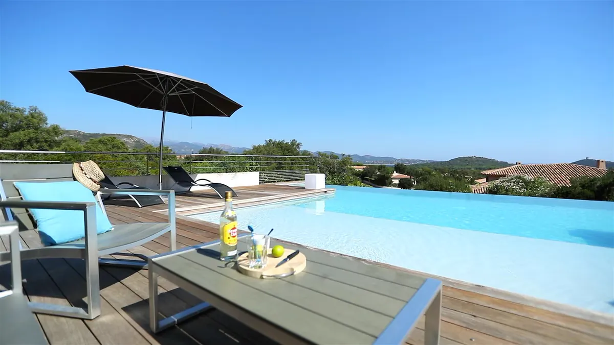 Transats et parasol au bord de la piscine